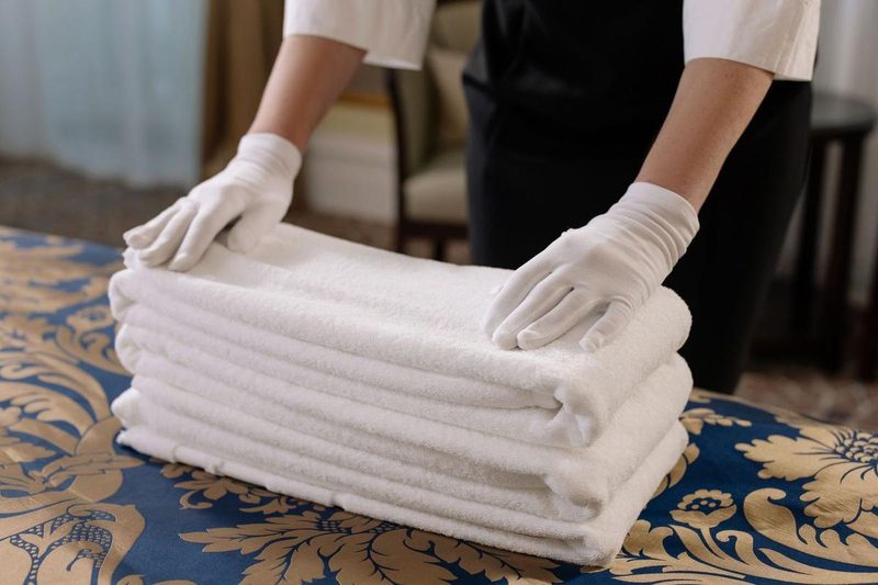 Toalhas brancas dobradas sobre uma cama de hotel